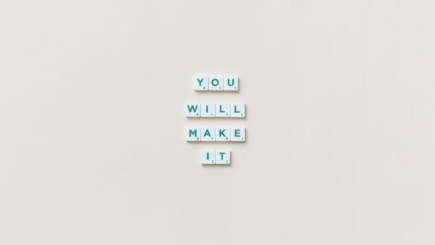 Motivational phrase 'You Will Make It' made from Scrabble tiles on a neutral background.